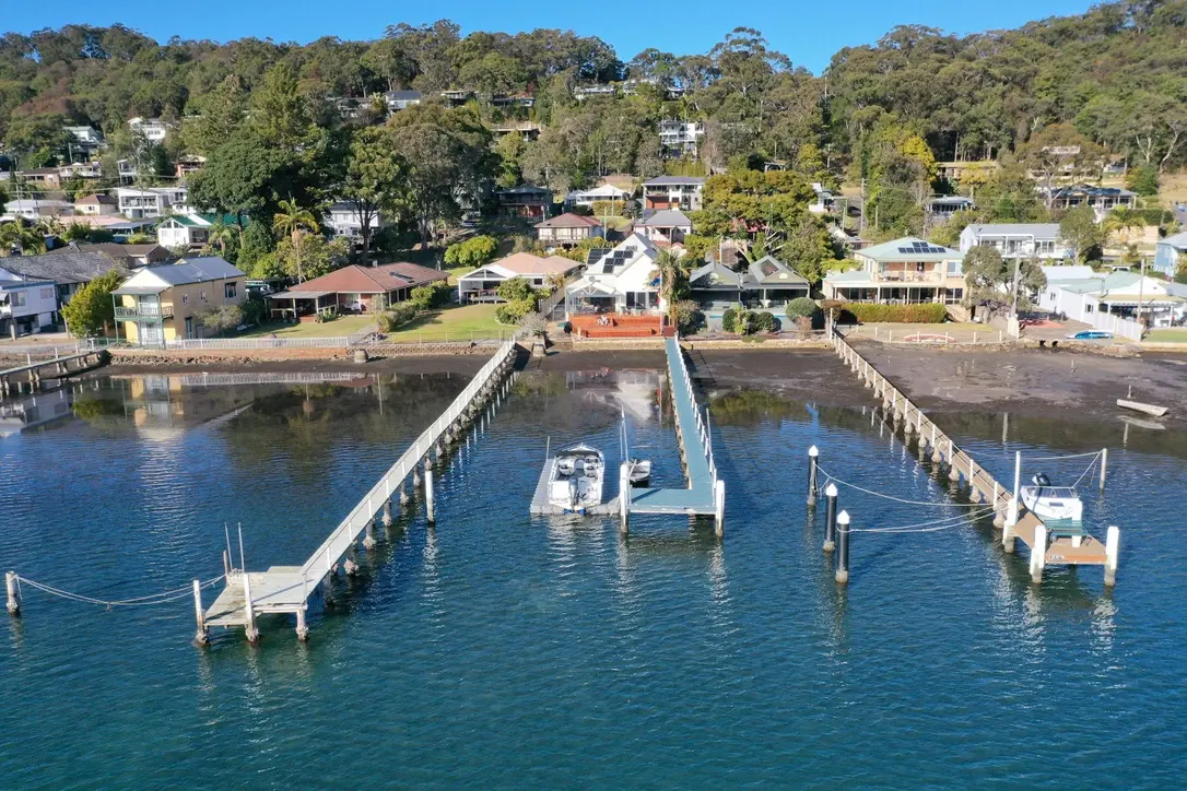 Aerial view of the waterfront property, jetty, floating pontoon and boats